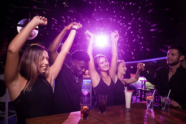 Group of friends dancing together in a lively club environment